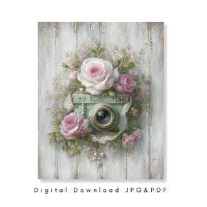 Puede incluir: Una impresión de arte digital de estilo vintage que presenta una cámara verde menta adornada con rosas rosas y delicado encaje blanco. La obra de arte está ambientada sobre un fondo de madera blanca desgastada. El texto "Digital Download JPG & PDF" está en la parte inferior.
