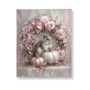 Könnte beinhalten: Gerahmtes Kunstwerk mit einem Eichhörnchen auf einem weißen Kürbis, daneben ein rosa Kürbis. Ein Kranz aus rosa Rosen und eine große Schleife umgeben das Eichhörnchen. Der Hintergrund ist ein weiches, gedämpftes Rosa.