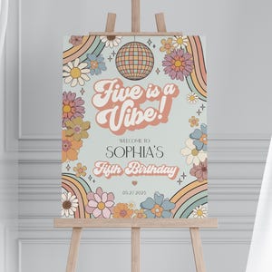May include: A retro-style birthday sign on an easel. The sign features the text "Five is a Vibe!" and "Sophia's Fifth Birthday" with floral and rainbow graphics. The date "05.27.2025" is also included.