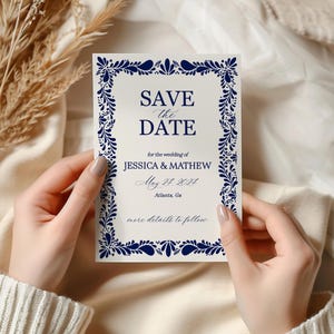 May include: A cream-colored wedding invitation with navy blue floral border and text. The text reads "SAVE the DATE" and includes the names Jessica & Mathew, the date May 27, 2027, and the location Atlanta, Ga.