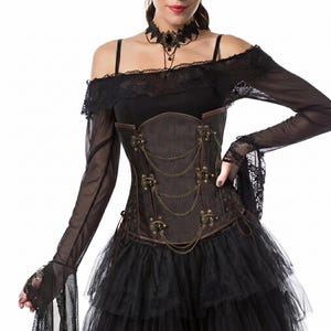 May include: A brown corset featuring bronze-toned metal clasps and draped chains across the front. The garment is worn with a black off-the-shoulder top with sheer long sleeves, lace trim, and a black choker necklace with a central dark stone.