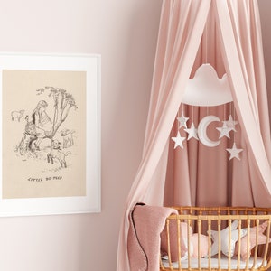 May include: A black and white illustration of Little Bo Peep with her sheep, framed in a white frame, hanging on a pink wall. A pink canopy hangs over a wicker bassinet with a white cloud and star mobile.