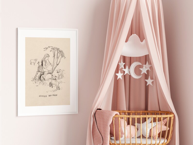 May include: A black and white illustration of Little Bo Peep with her sheep, framed in a white frame, hanging on a pink wall. A pink canopy hangs over a wicker bassinet with a white cloud and star mobile.