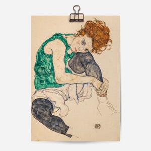 May include: A drawing of a person sitting with their legs crossed. The person is wearing a green sleeveless top and black pants. The person has red hair and is looking down.