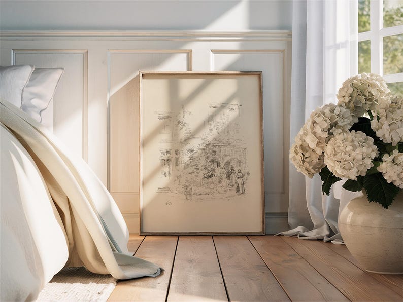 May include: A white bed with a white blanket and a white pillow. A framed black and white drawing of a building is on the wall behind the bed. A bouquet of white hydrangeas is in a white vase on the floor next to a white curtain.