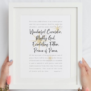May include: A framed print with a white background and gold text. The text reads "For to us a child is born, to us a son is given: and the government shall be upon his shoulder, and his name shall be called Wonderful Counselor, Mighty God, Everlasting Father, Prince of Peace. Of the increase of his government and of peace there will be no end, on the throne of David and over his kingdom, to establish it and to uphold it with justice and with righteousness from this time forth and forevermore. The zeal of the Lord of hosts will do this. Isaiah 9:6-7"