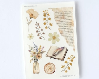 May include: A 4.5 inch by 6.5 inch sheet of transparent matte stickers titled Sentimental Journal Stickers. The sheet features watercolor illustrations of various yellow and brown flowers, a glass bottle, an open book with a feather quill, and a wax seal.