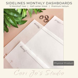 May include: Three white sheets of paper with the words "January", "November", and "Thoughts" written on them. The sheets are on a peach-coloured surface with green leaves and black hair ties. The text "SIDELINES MONTHLY DASHBOARDS" is at the top of the image. The text "12 Months/1 Year | Half-Letter Sized | Premium Vellum" is below the title. The text "Physical Product" is in a white rectangle at the bottom of the image. The text "Cori Jo's Studio" is at the bottom of the image.