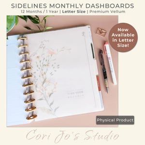 May include: A letter-size planner with gold rings, featuring floral designs and the text "FIND YOUR BALANCE." The image includes pens, a paperclip, and the text "SIDELINES MONTHLY DASHBOARDS." The planner is available in letter size.