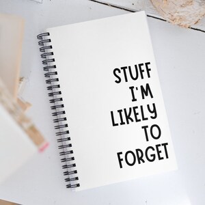 Puede incluir: Una libreta blanca de espiral con el texto "STUFF I'M LIKELY TO FORGET" escrito en negro.