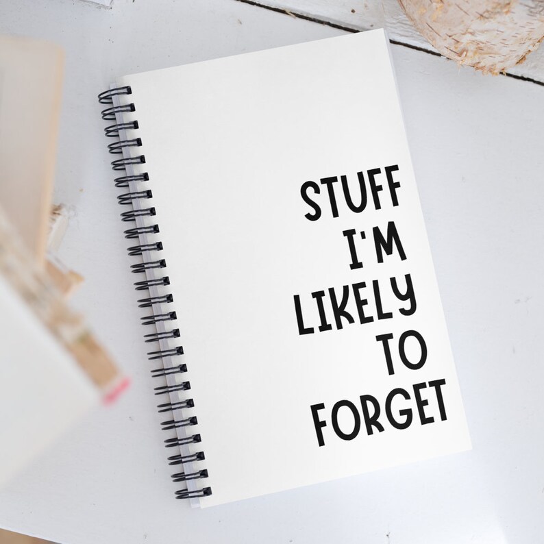 Puede incluir: Una libreta blanca de espiral con el texto "STUFF I'M LIKELY TO FORGET" escrito en negro.