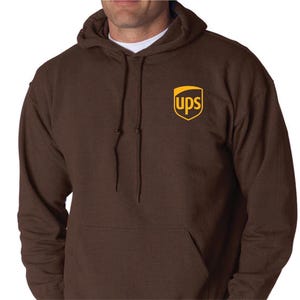 May include: A brown hooded sweatshirt with a kangaroo pocket and a drawstring. The UPS logo is printed on the upper left chest. The sweatshirt is made of a soft material.