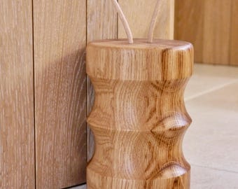 Personalisierter Türstopper aus Holz, handgedreht in massiver Eiche. Griffschlaufen aus Naturleder passend zum Holz
