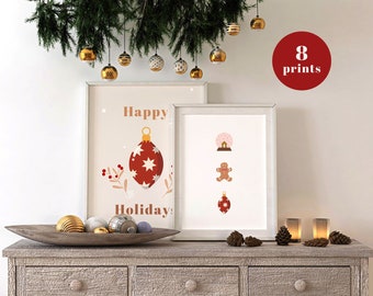 Puede incluir: Dos ilustraciones imprimibles con temática navideña. La primera ilustración presenta un adorno rojo con estrellas blancas y el texto "Happy Holiday!" La segunda ilustración presenta un hombre de jengibre, una bola de nieve y un adorno rojo. Las ilustraciones están enmarcadas y se muestran en una mesa de madera con una rama de pino y adornos colgando arriba.