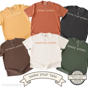 May include: A collection of six short-sleeve crew neck t-shirts in yellow, rust, black, brown, white, and green. Each shirt features a unique text print: silly potato, sweet potato, sorta rude potato, sarcastic potato, smartass potato, and sassy potato.