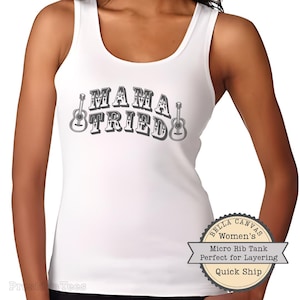 Könnte beinhalten: Weißes Tanktop mit dem Text "MAMA TRIED" in Retro-Schriftart, flankiert von Gitarrenillustrationen. Das Shirt ist ein Bella Canvas Micro Rib Tank.