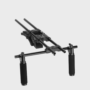 May include: Black camera rig with two handles and multiple rods. The rig has a central mounting platform and two padded handles for comfortable grip. The design is sleek and modern, suitable for professional video recording.