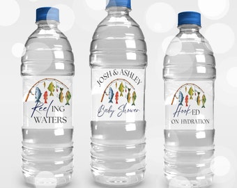 May include: Three clear plastic water bottles with labels featuring a fishing theme. The labels have a blue and white color scheme with illustrations of fishing rods and colorful fish. The text on the labels reads "Reeling Waters", "Josh & Ashley Baby Shower", and "Hooked on Hydration".