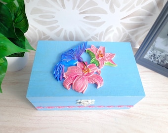Caja de recuerdos decorativa pintada a mano: Colibrí y flores en resina sobre fondo azul.