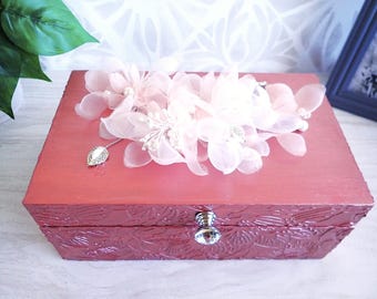 Getextureerde roze bronskleurige houten doos met een spray van delicate organdebloemen erop.