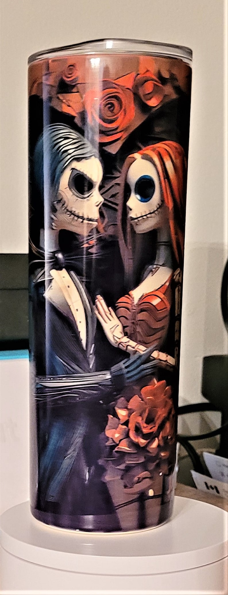 Pu&ograve; includere: Un bicchiere nero e bianco con una grafica di Jack Skellington e Sally del film L'incubo prima di Natale. La grafica presenta una rosa rossa e uno sfondo nero.