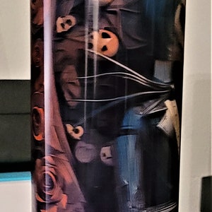 Pu&ograve; includere: Un bicchiere alto e trasparente con un design nero e arancione che presenta pi&ugrave; volti. Il design ricorda un film horror.