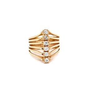 May include: A gold ring with five small diamonds set in a vertical line. The ring has a delicate, openwork design with multiple bands.