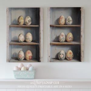 Peut inclure: Deux étagères en bois vintage avec des œufs peints à fleurs sur chaque étagère. Les étagères sont peintes d'une couleur bleu clair et ont un aspect vieilli. Il y a six œufs sur chaque étagère, et ils sont tous de couleurs et de motifs différents. Les œufs sont disposés de manière symétrique sur les étagères. Il y a aussi quelques œufs de couleur pastel dans un panier au centre inférieur de l'image.