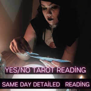 May include: A person holding tarot cards, illuminated by soft light. The image features the text "YES/NO TAROT READING" and "SAME DAY DETAILED READING" in a neon-style font. The scene is set in a dimly lit environment, suggesting a mystical theme.
