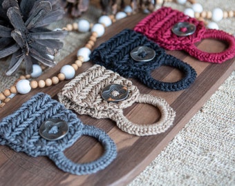 May include: Four crocheted pot holders with a woven pattern and metal button accents. The pot holders are in shades of gray, brown, black, and red.