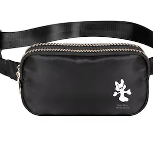 May include: Black fanny pack with two zippered compartments and an adjustable black strap. The pack features a white graphic and the text "Right Place Wrong Person". The zippers are silver.