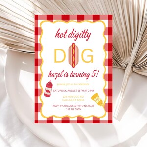 Pode incluir: Um convite de festa de anivers&aacute;rio em xadrez vermelho e branco com o texto "hot digitty DOG hazel is turning 5!" O convite inclui um cachorro-quente de desenho animado com mostarda e ketchup. O texto tamb&eacute;m inclui a data, a hora, o endere&ccedil;o e as informa&ccedil;&otilde;es de RSVP.