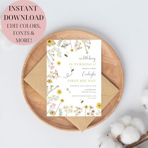 Puede incluir: Una invitaci&oacute;n imprimible para una fiesta de primer cumplea&ntilde;os con tem&aacute;tica de abejas. La invitaci&oacute;n presenta un fondo blanco con flores amarillas, rosas y blancas, abejas y el texto "&iexcl;Nuestro peque&ntilde;o miel cumple 1 a&ntilde;o! &Uacute;nase a nosotros para celebrar el primer d&iacute;a de abeja de Everleigh. S&aacute;bado 7 de julio a las 4 PM. 123 Honey Rd. Dallas, TX 75215. RSVP a Nicole antes del 1 de julio. 555-555-5555."