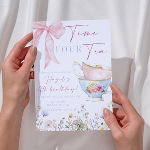 May include: A floral invitation card with the text "Time Four Tea" and a watercolor illustration of stacked teacups. A pink bow and floral accents adorn the card, which is held by two hands.