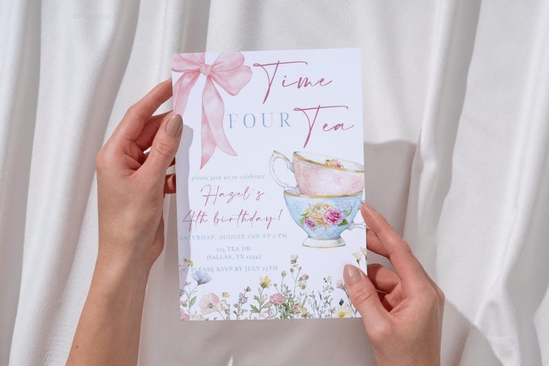 May include: A floral invitation card with the text "Time Four Tea" and a watercolor illustration of stacked teacups. A pink bow and floral accents adorn the card, which is held by two hands.