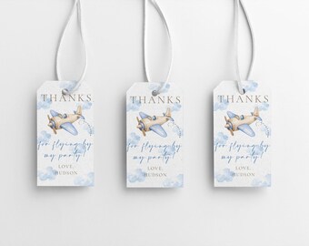 May include: Three white gift tags featuring a watercolour airplane design. Each tag has the word "THANKS" at the top, with the text "for flying by my party!" and "LOVE HUDSON" below. The tags are tied with white ribbon.