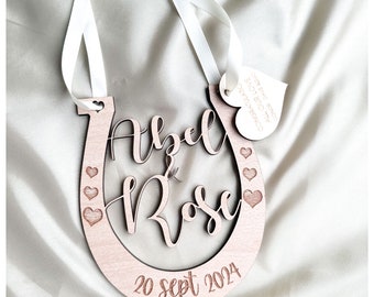 May include: Wooden horseshoe with the names Abel & Rose and the date 20 Sept 2024 engraved on it. A small heart-shaped tag with the text "Congratulations, all our love, forever and always" is attached to the horseshoe.