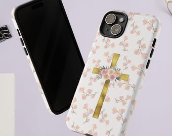 May include: A white phone case with a gold cross and pink floral design. The case is compatible with iPhone models.