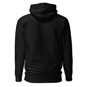 May include: A solid black hoodie with a hood and long sleeves. The back view of the hoodie is shown, highlighting the simple design and the texture of the fabric. The hoodie has a drawstring and a kangaroo pocket.