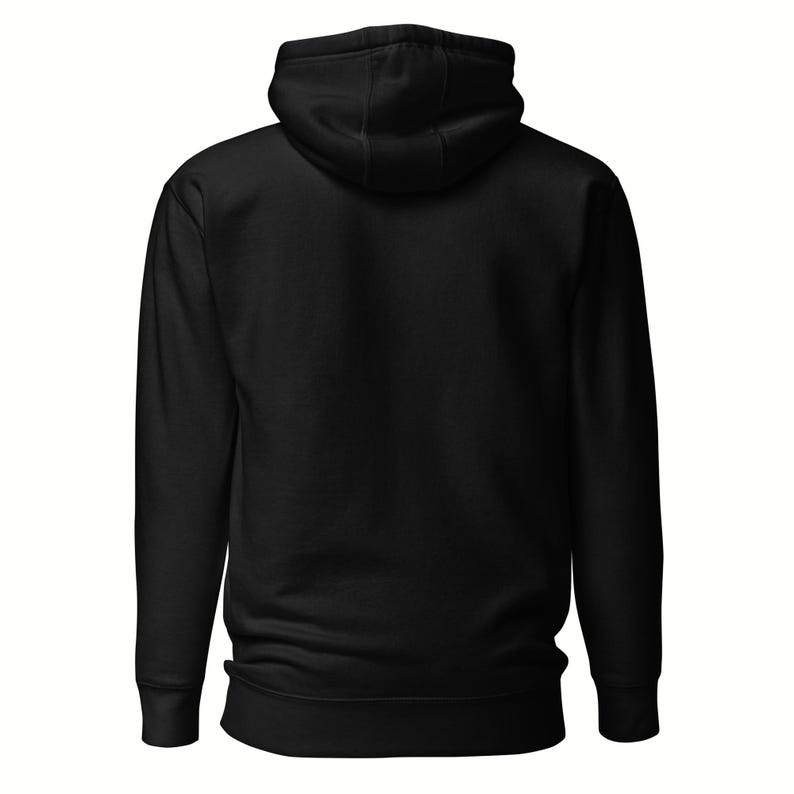 May include: A solid black hoodie with a hood and long sleeves. The back view of the hoodie is shown, highlighting the simple design and the texture of the fabric. The hoodie has a drawstring and a kangaroo pocket.