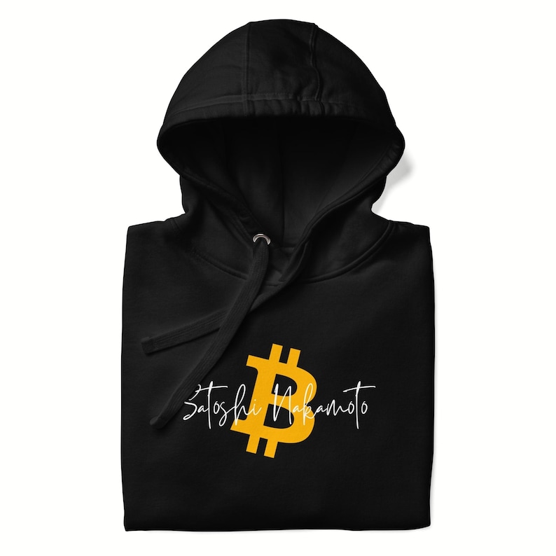 May include: Black hooded sweatshirt featuring a gold Bitcoin symbol and the name "Satoshi Nakamoto" in a white script font. The hoodie has a drawstring and a front pocket.