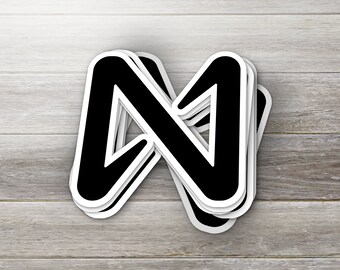 May include: A stack of black and white stickers with a stylized letter N design.