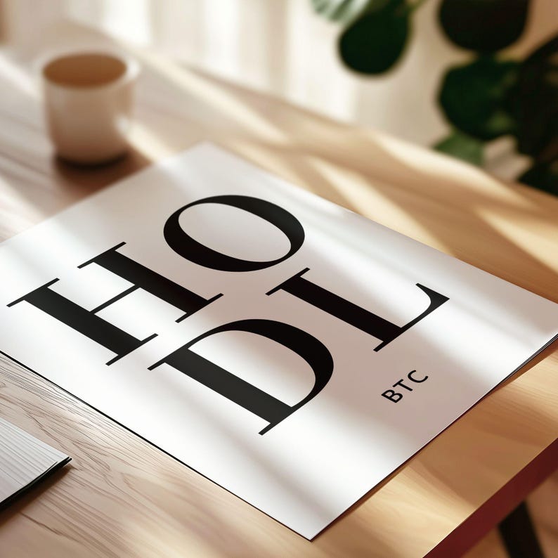 May include: A white poster with the word "HODL" in large black letters. The word "BTC" is written in smaller letters below the word "HODL".