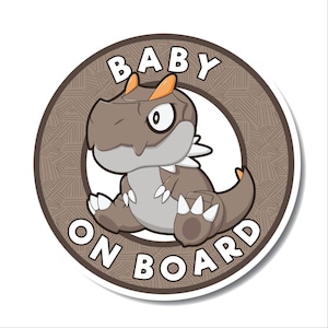 Könnte beinhalten: Ein braunes und graues Cartoon-Dinosaurier mit orangefarbenen Stacheln auf dem Kopf. Der Dinosaurier sitzt auf einem braunen Kreis mit dem Text "BABY ON BOARD" in Weiß.