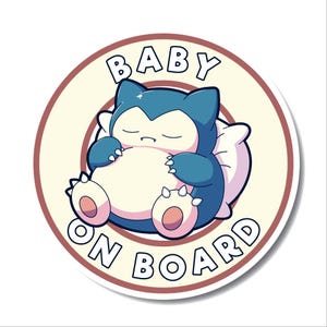 Könnte beinhalten: Ein runder Aufkleber mit hellbraunem Hintergrund und rotem Rand. Der Aufkleber zeigt in brauner Schrift "BABY ON BOARD". In der Mitte des Aufklebers schläft ein blauer und weißer Snorlax-Cartoon auf einem weißen Kissen.