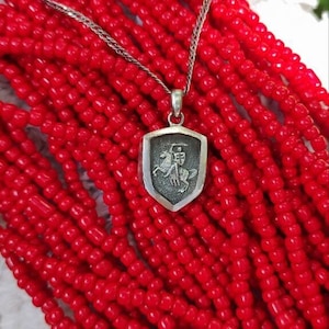oxidized silver pendant with the coat of arms "The Chase", the national symbol of Belarus, Lithuania. The coat of arms depicts a knight on horseback, the knight is holding a sword and shield