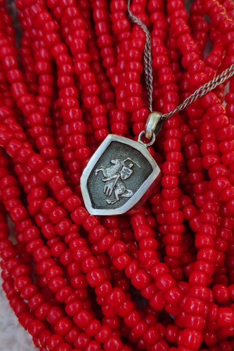 oxidized silver pendant with the coat of arms "The Chase", the national symbol of Belarus, Lithuania. The coat of arms depicts a knight on horseback, the knight is holding a sword and shield