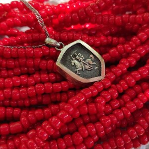 oxidized silver pendant with the coat of arms "The Chase", the national symbol of Belarus, Lithuania. The coat of arms depicts a knight on horseback, the knight is holding a sword and shield