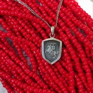 oxidized silver pendant with the coat of arms "The Chase", the national symbol of Belarus, Lithuania. The coat of arms depicts a knight on horseback, the knight is holding a sword and shield