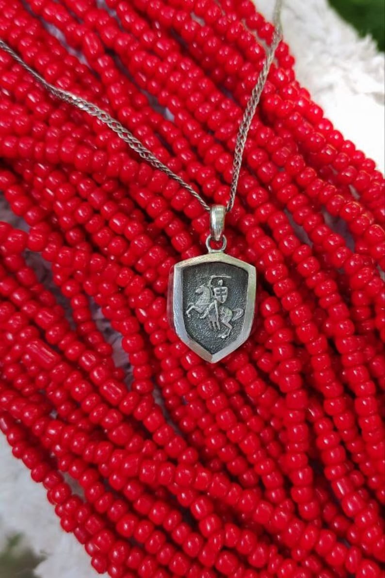 oxidized silver pendant with the coat of arms "The Chase", the national symbol of Belarus, Lithuania. The coat of arms depicts a knight on horseback, the knight is holding a sword and shield